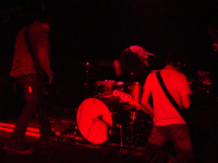 a band playing on stage with a man standing in front of him