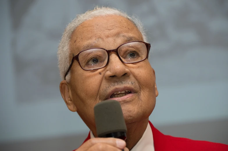 an older man with glasses and a red suit