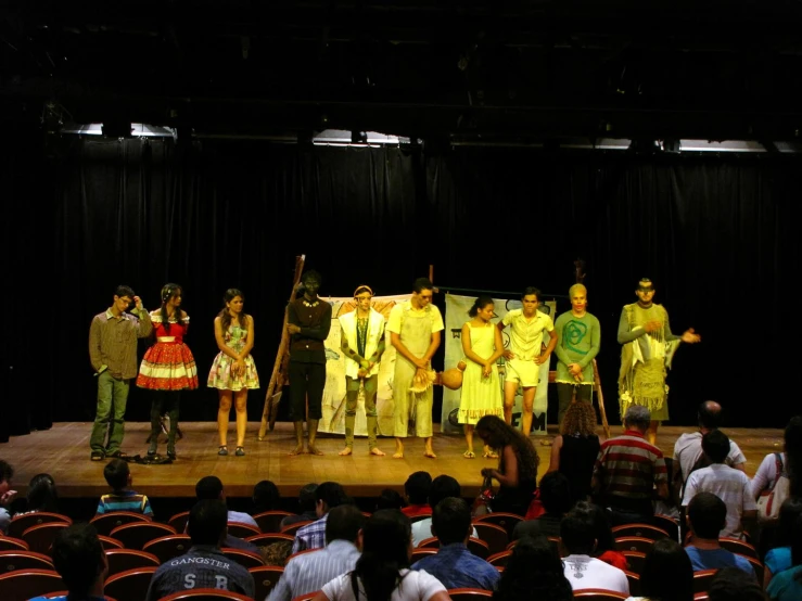 a group of people on stage with instruments and costumes