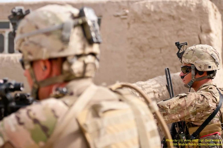 two soldiers with guns on their heads looking back