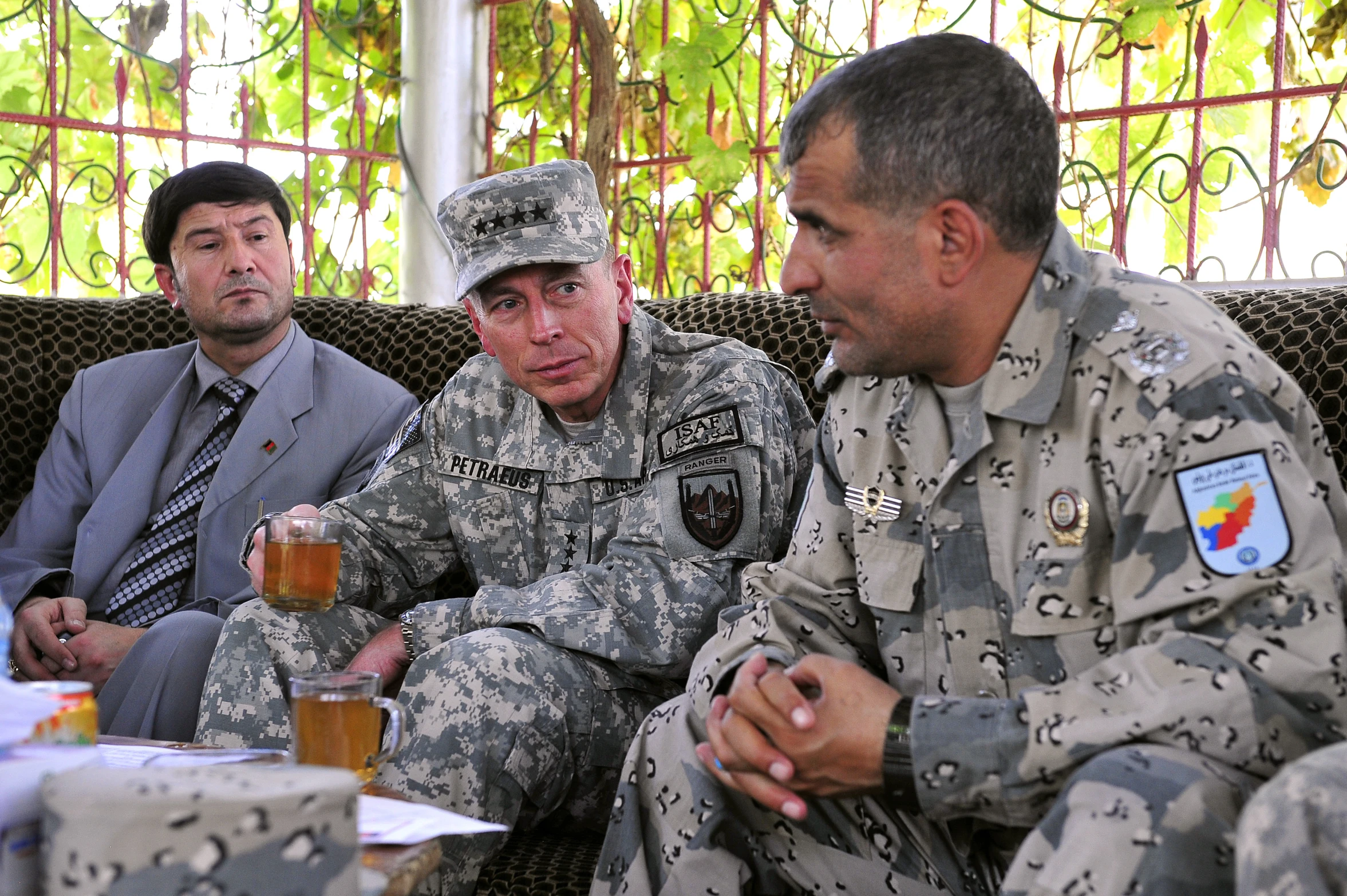 men in uniform are sitting together with drinks in front of them