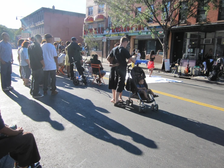 several people are standing and watching a woman in a stroller