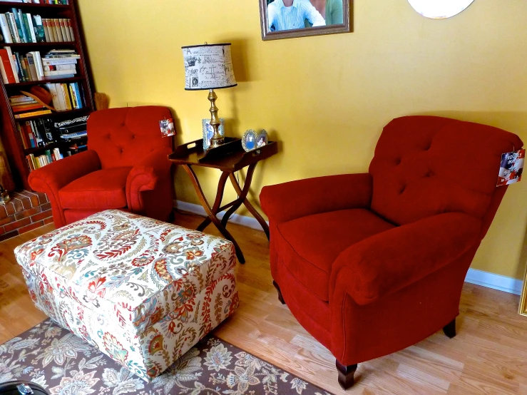 there is an old red chair and chair next to the small table