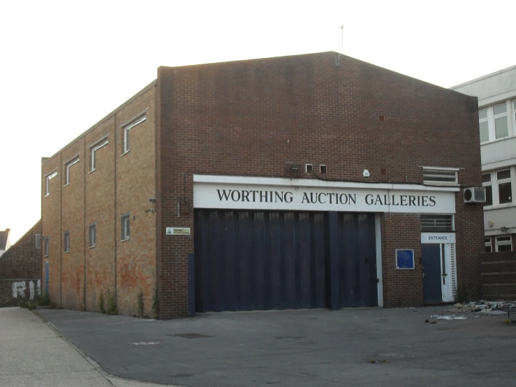 a brown brick building with the word worthing auction gardens on it