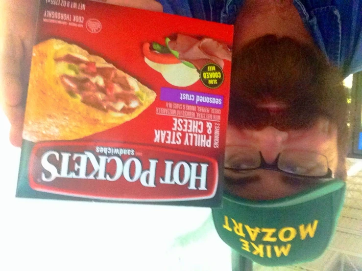 man with beard holding up a box of chicken pizza