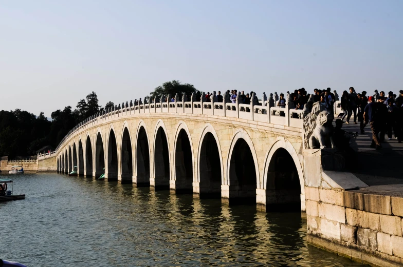 people standing on the edge of a bridge