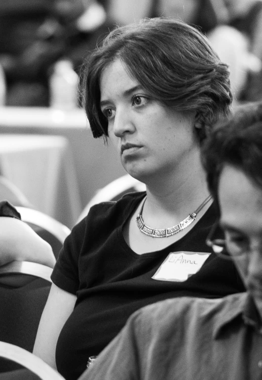 a black and white image of people sitting side by side