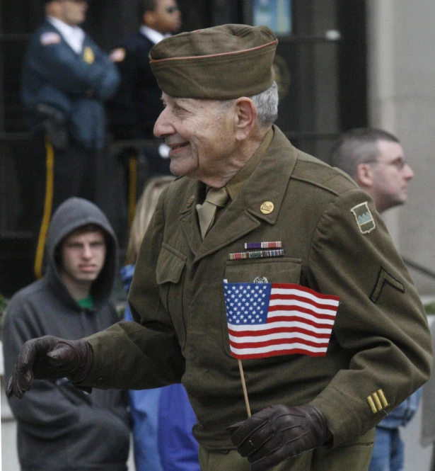 a man in military uniform holding a small american flag on stick