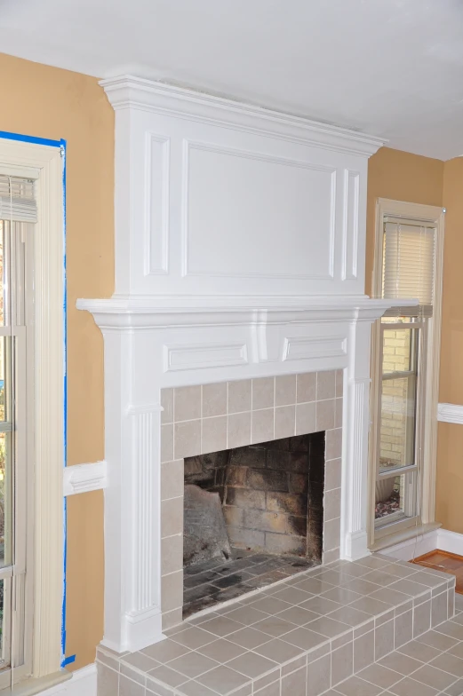 this living room has a tile floor and white fireplace