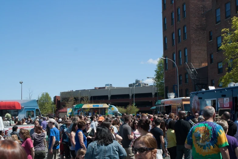 a crowd of people at a festival near a building