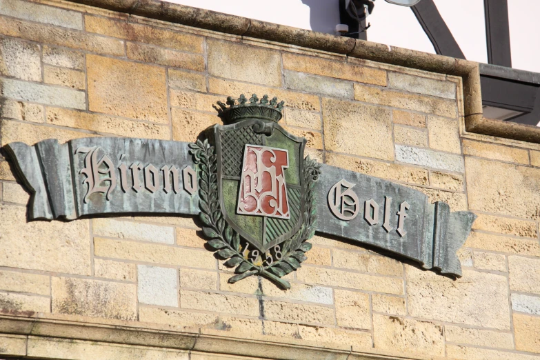 a brick wall with an elaborate metal crest on it