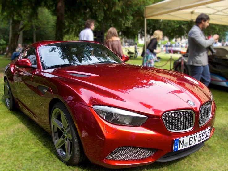 a bright red sports car parked on the grass