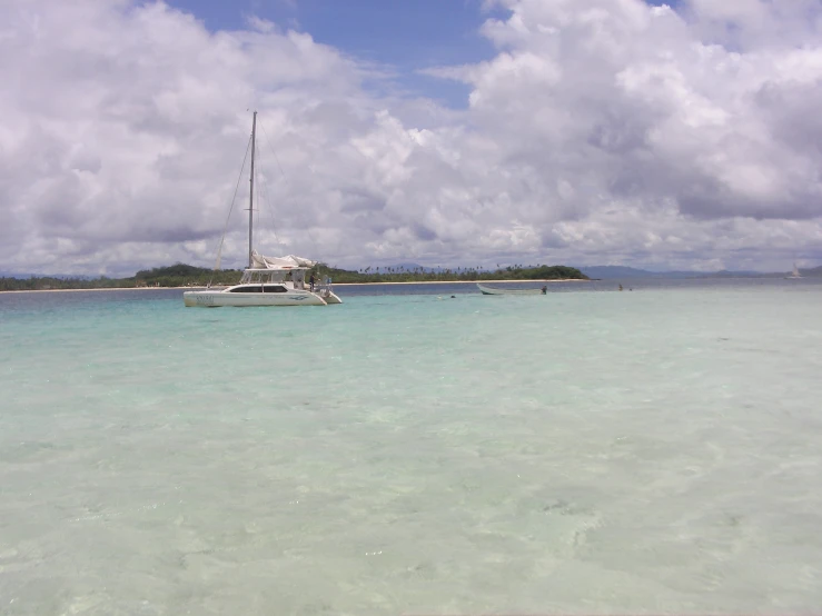 a small boat sits in the clear blue water