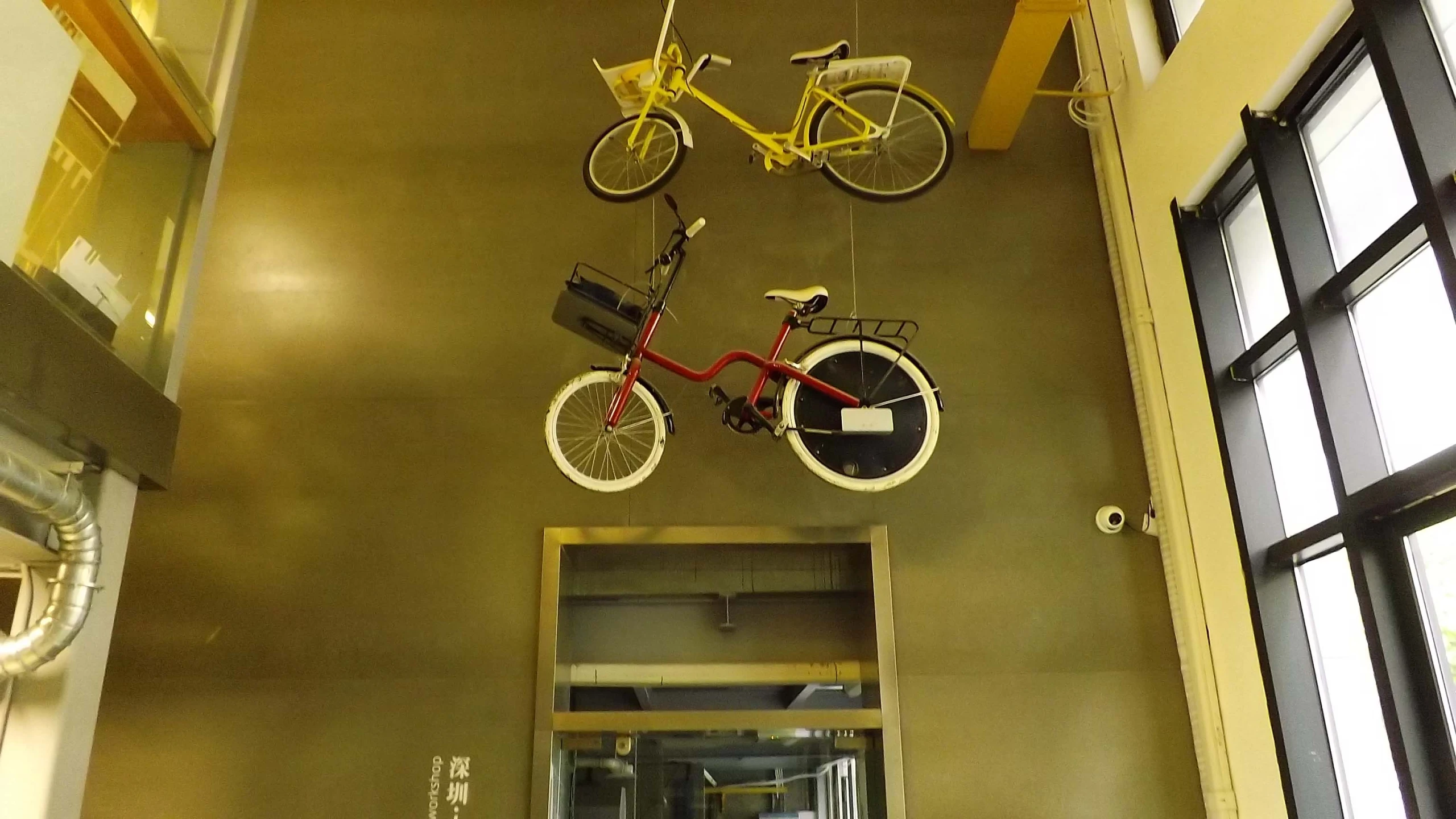 two bicycles hanging from the ceiling of a building