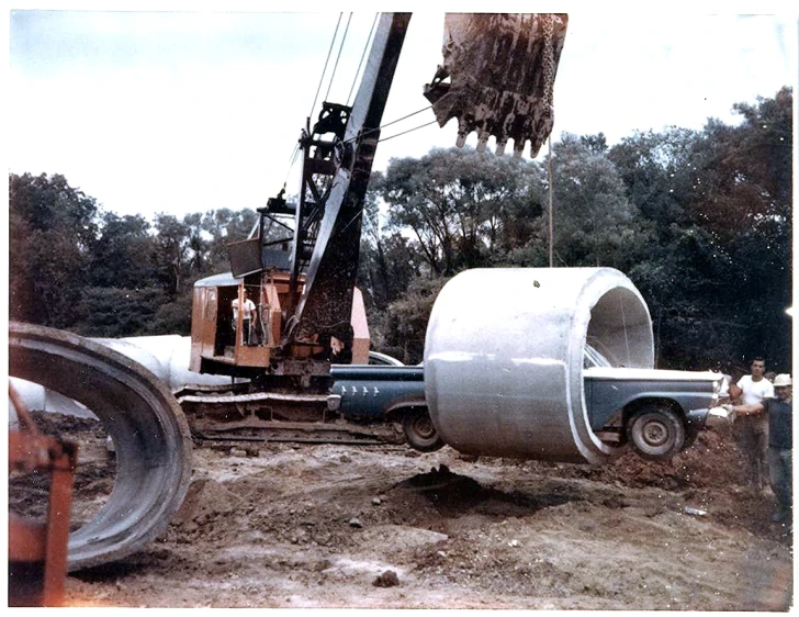 a crane and some pipes in a field