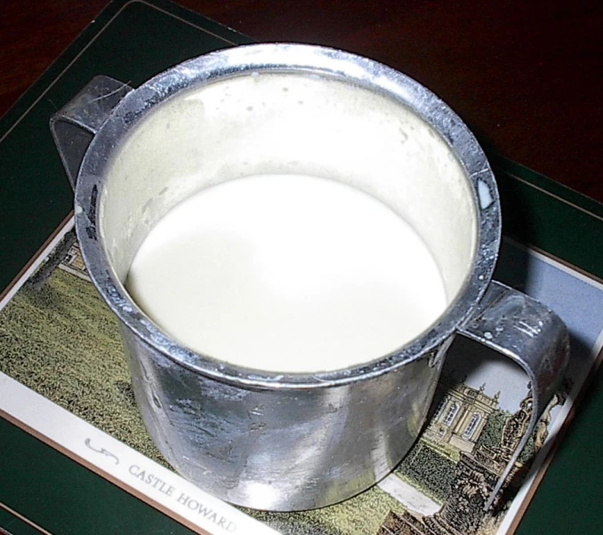 a metal pot filled with liquid sitting on top of a mat