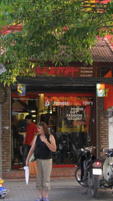 there is a woman holding a piece of paper near the motorcycle