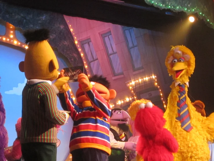 a group of sesame and muppet characters are standing on stage