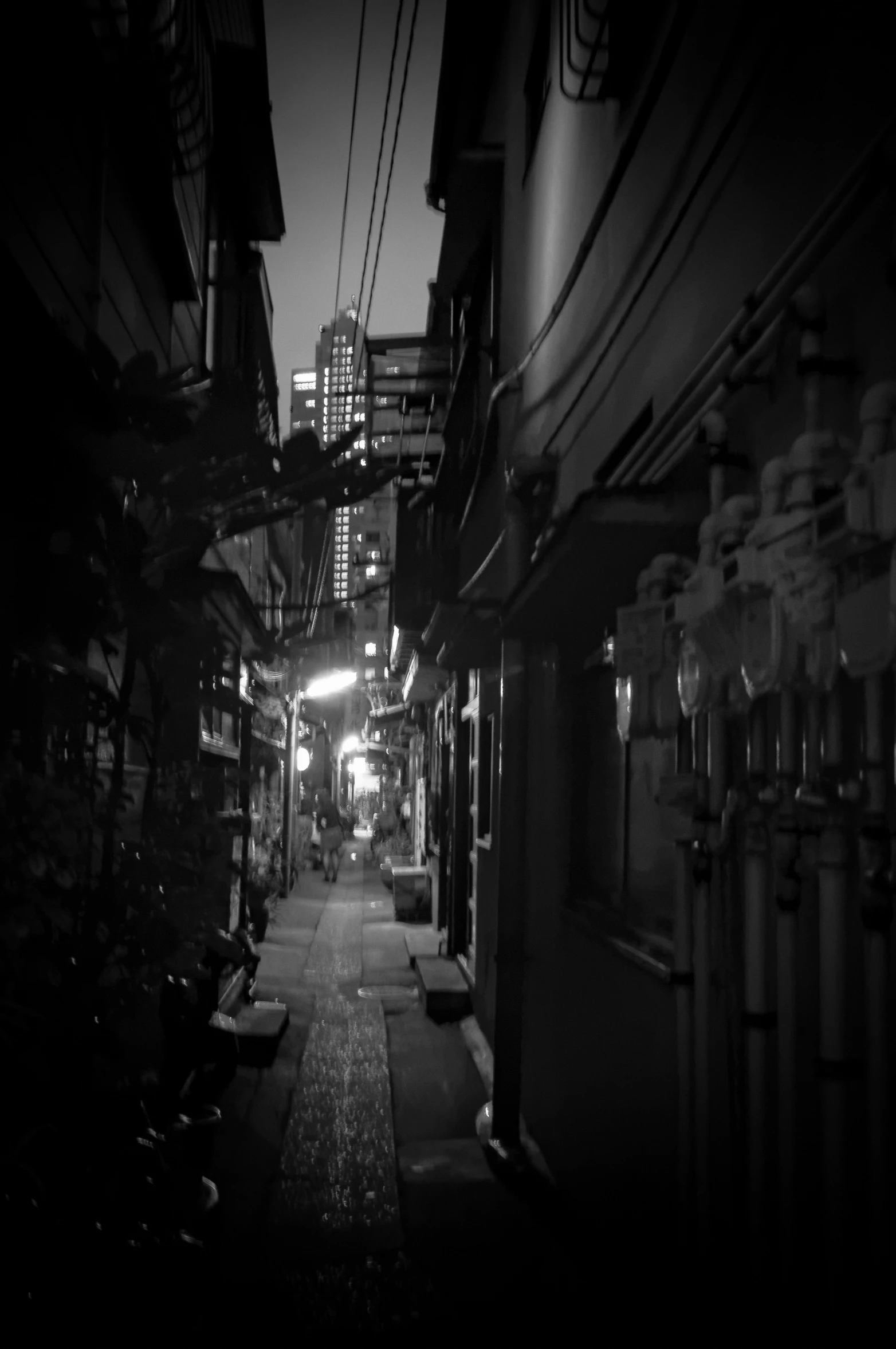 a black and white po of the streetlight over an alley