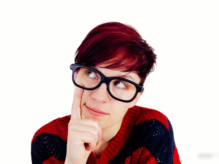 a girl in glasses has a hand under her chin