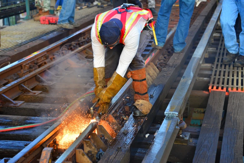 a worker in work gear  metal near a train track