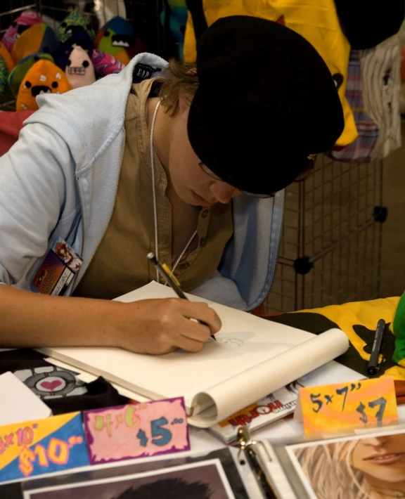 a young person writing in an notebook on a table