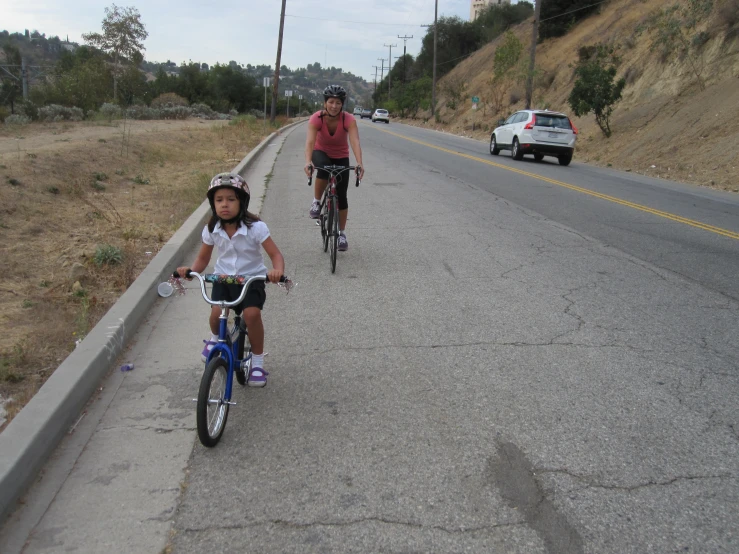 two children on bikes on the side of the road