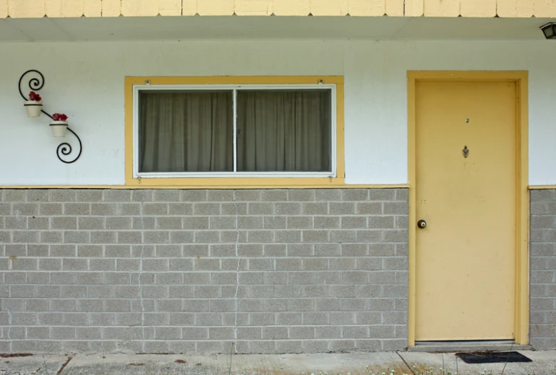 a yellow and gray door a brick house and a brown window