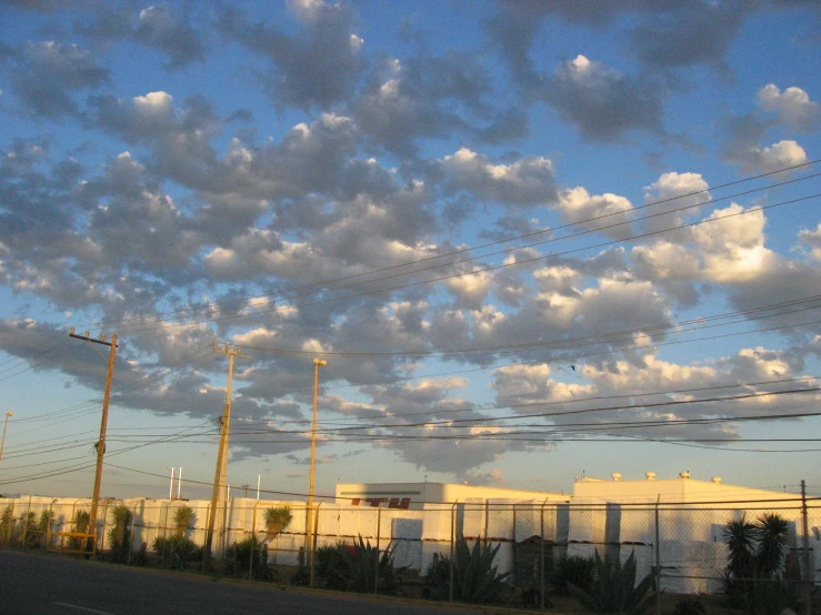 power lines across from some buildings under cloudy skies