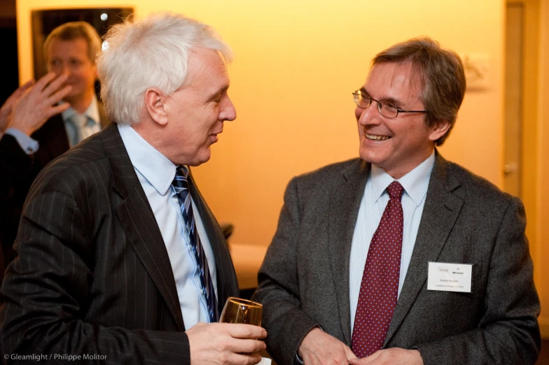 two men in suits standing next to each other