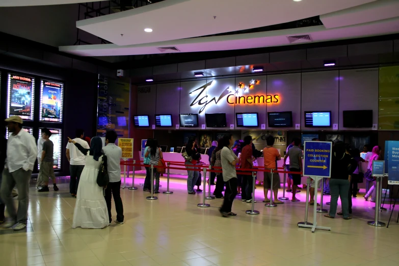 the group of people are standing together in front of the television screens