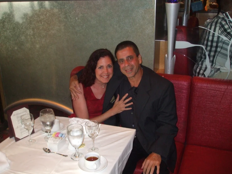 two people are posing for a picture at a table