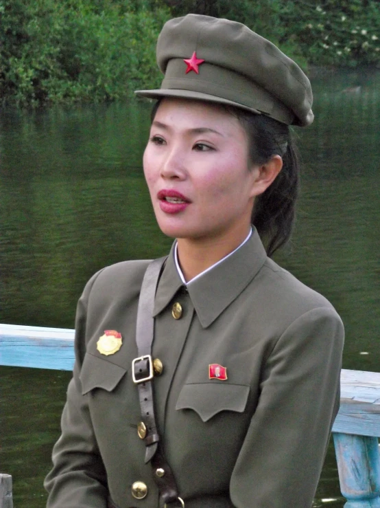 a women in military dress uniform sitting on a bench