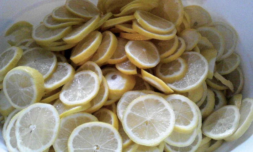 sliced lemons and onions in a white bowl