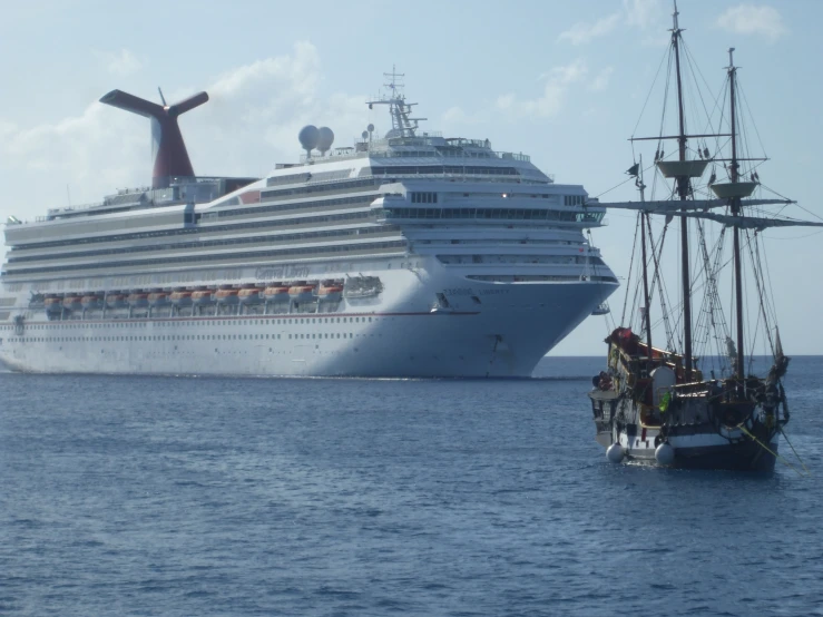 a boat and cruise ship are floating near the shore