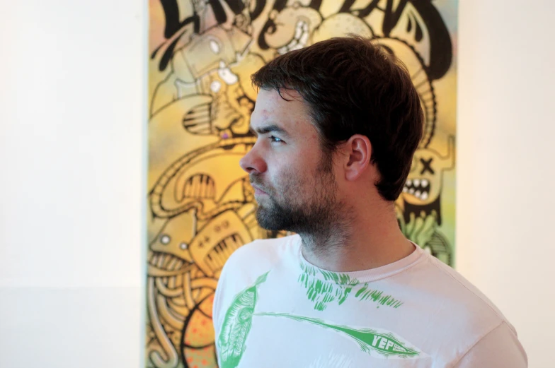 a close up of a man with a beard wearing a white shirt