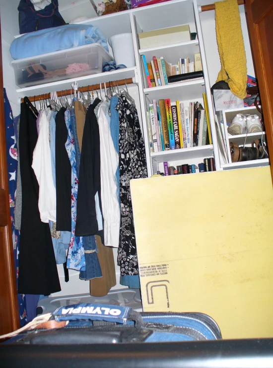 a white closet filled with clothes and other items