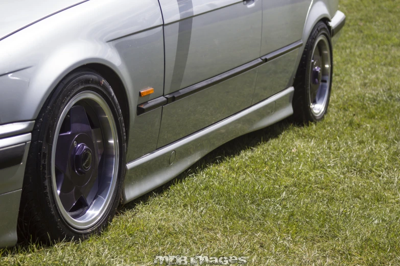 an old car parked in the grass with its rims