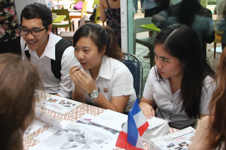 four people sitting around a table with papers on it