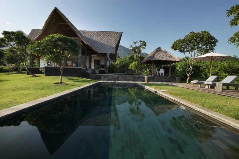 a large pool area in front of a small cottage