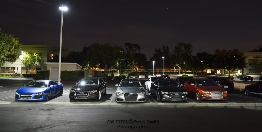 group of vehicles parked in parking lot of residential area at night