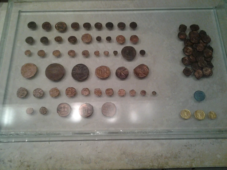 a white display case with various coins in it