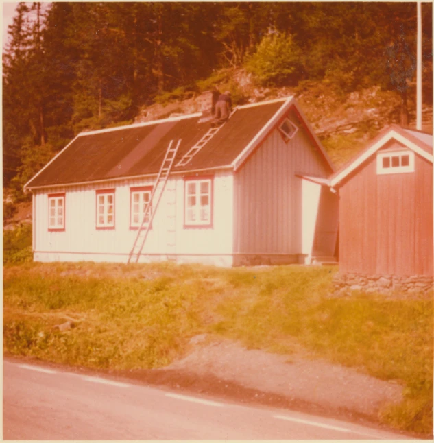 small white house on corner by the side of the road