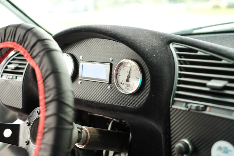 an interior s of a car with leather steering wheel and gauges