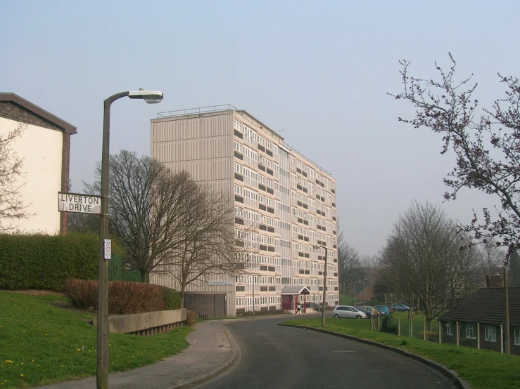 two building sit in the back of a row of trees