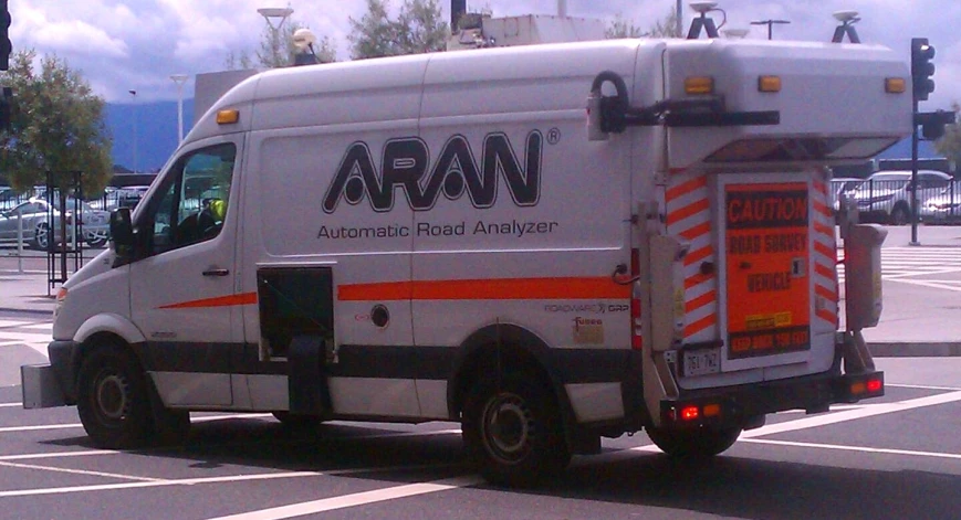 an awn moving truck driving across the street