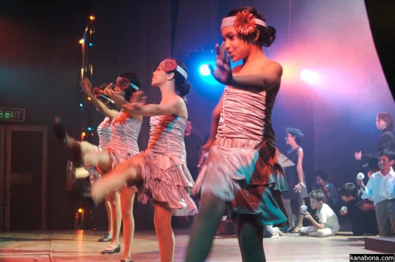 dancers perform at an event as a crowd watches