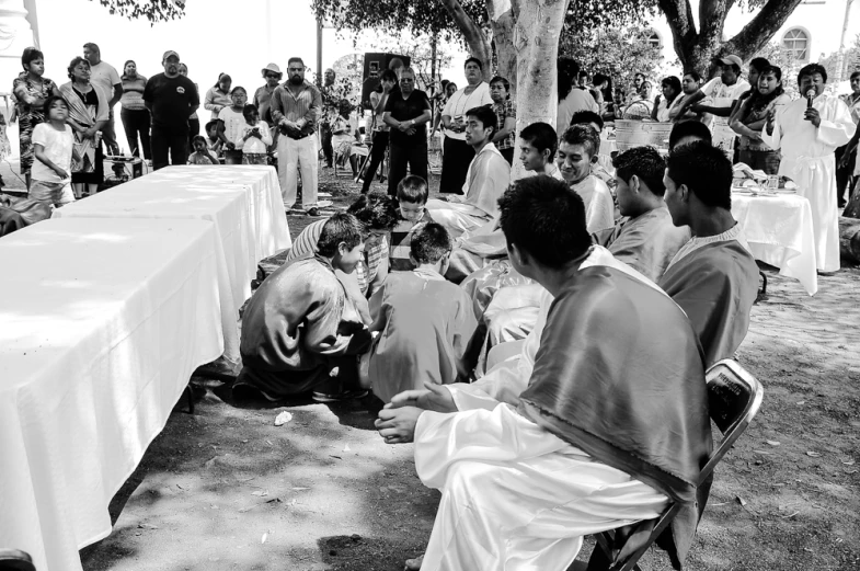 a group of people sitting around a table with some white tables