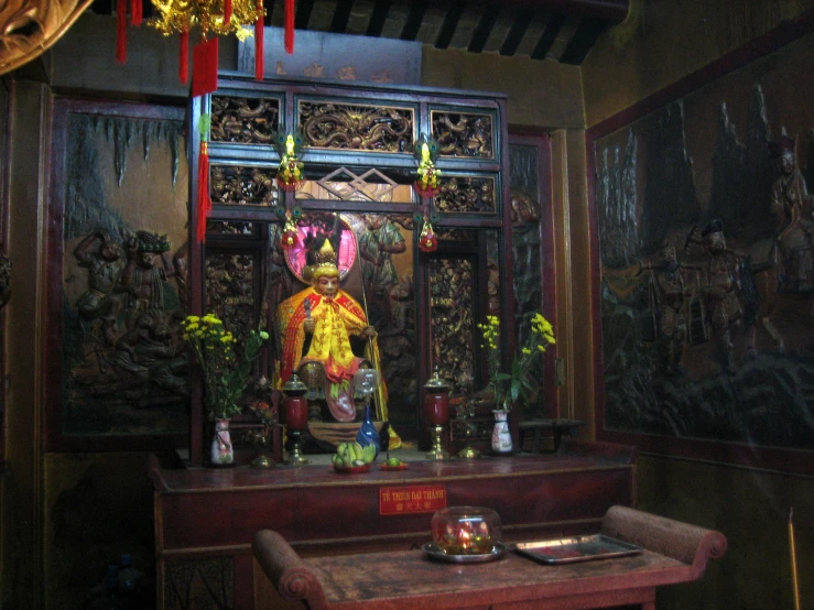 a buddhist shrine is shown in front of several large paintings