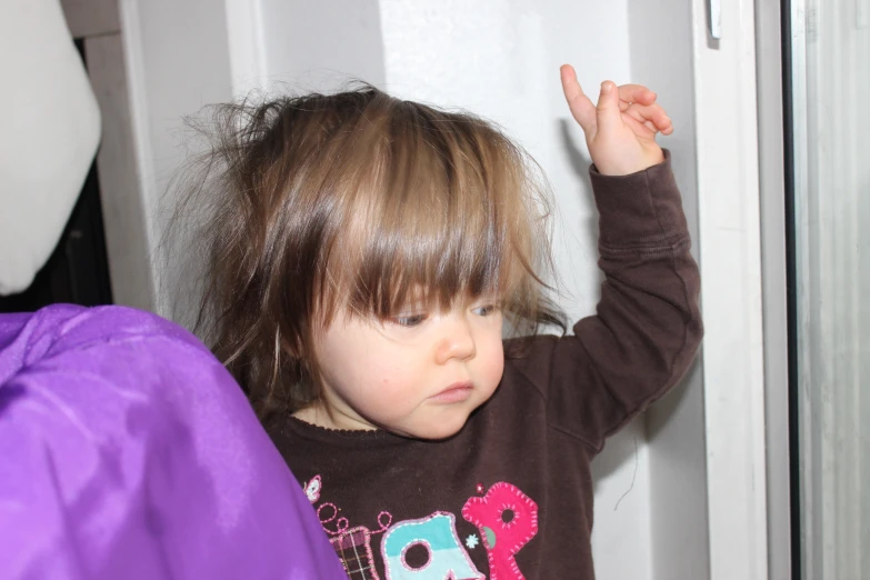 a little girl with short brown hair and purple pants